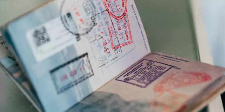 A passport open to two pages with lots of immigration stamps