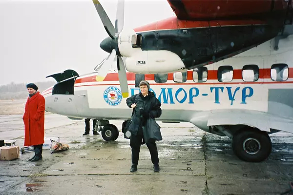 Lynne Viola stand in front of an old airplane