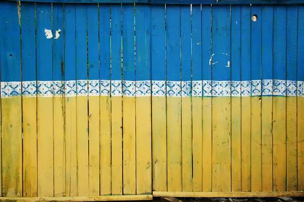 A wooden fence painted in the colours of the Ukraine flag