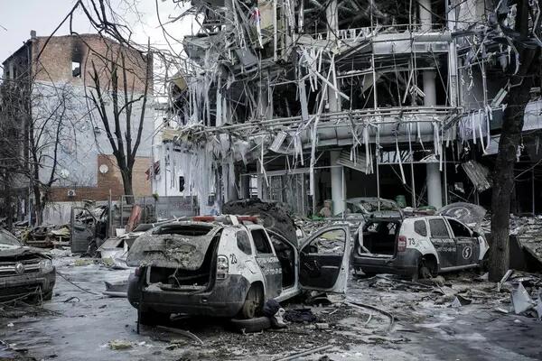 Ukrainian theatre hit by an airstrike, damaged police cars in front of the bombed out building