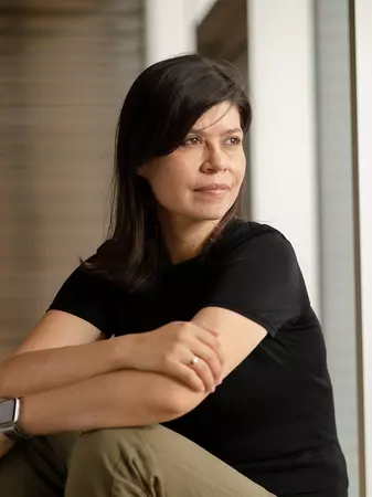 Picture of Martha Balaguera sitting by a window wearing black shirt. 