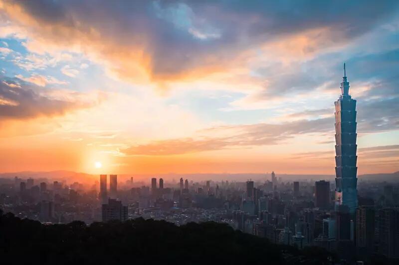 Taipei skyline at sunset, with the Taipei 101 building towering over the city in the right corner of the photo