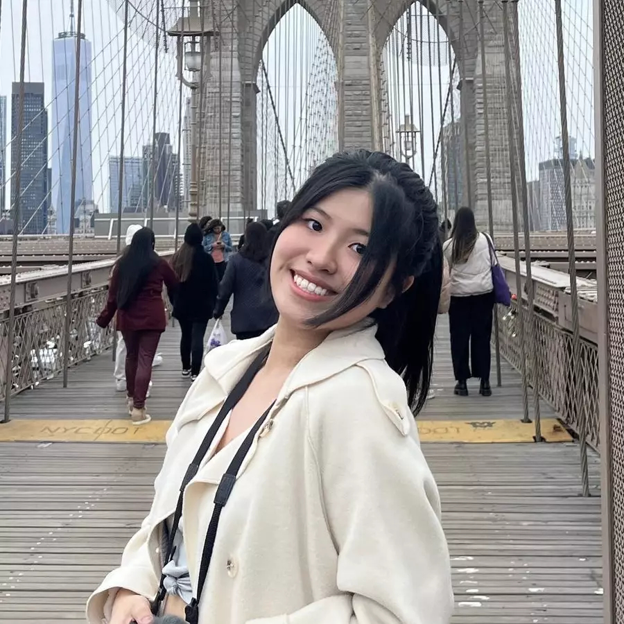Woman wearing white coat smiling on a bridge