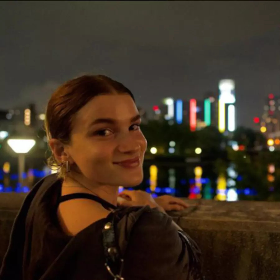 Woman standing in front of a night time skyline