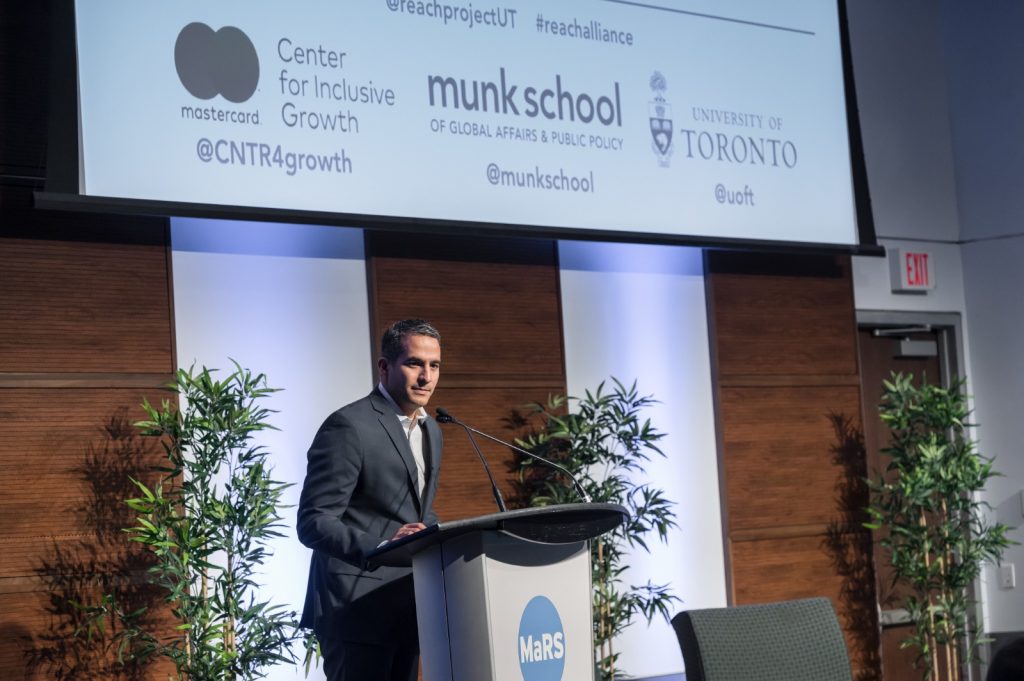 Arturo Franco speaks from a podium at a Reach Alliance event