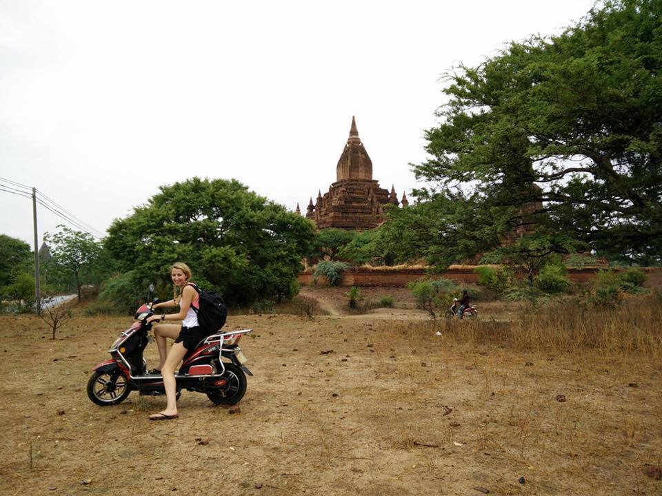 Jillian Sprenger on a moped with a temple in the background