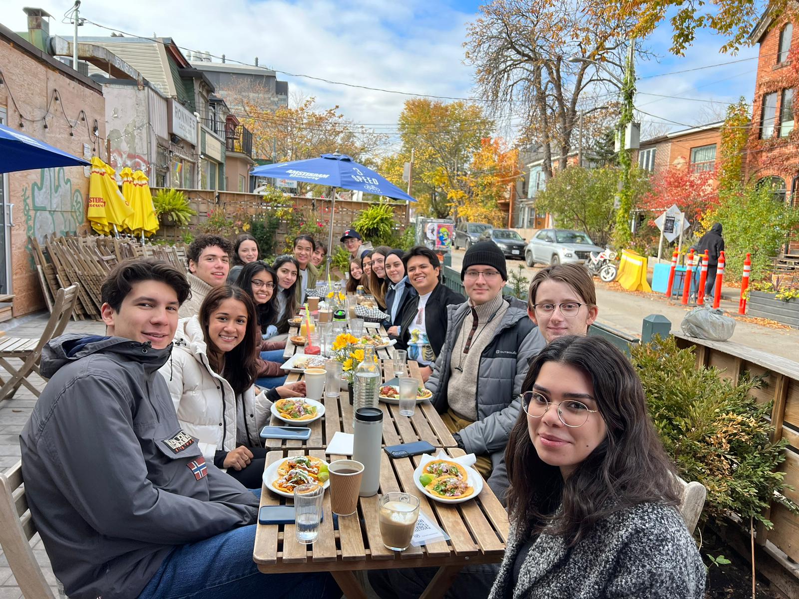 The Munk One 2022-23 Cohort having lunch after conducting fieldwork for the Ethnography of Kensington Market.