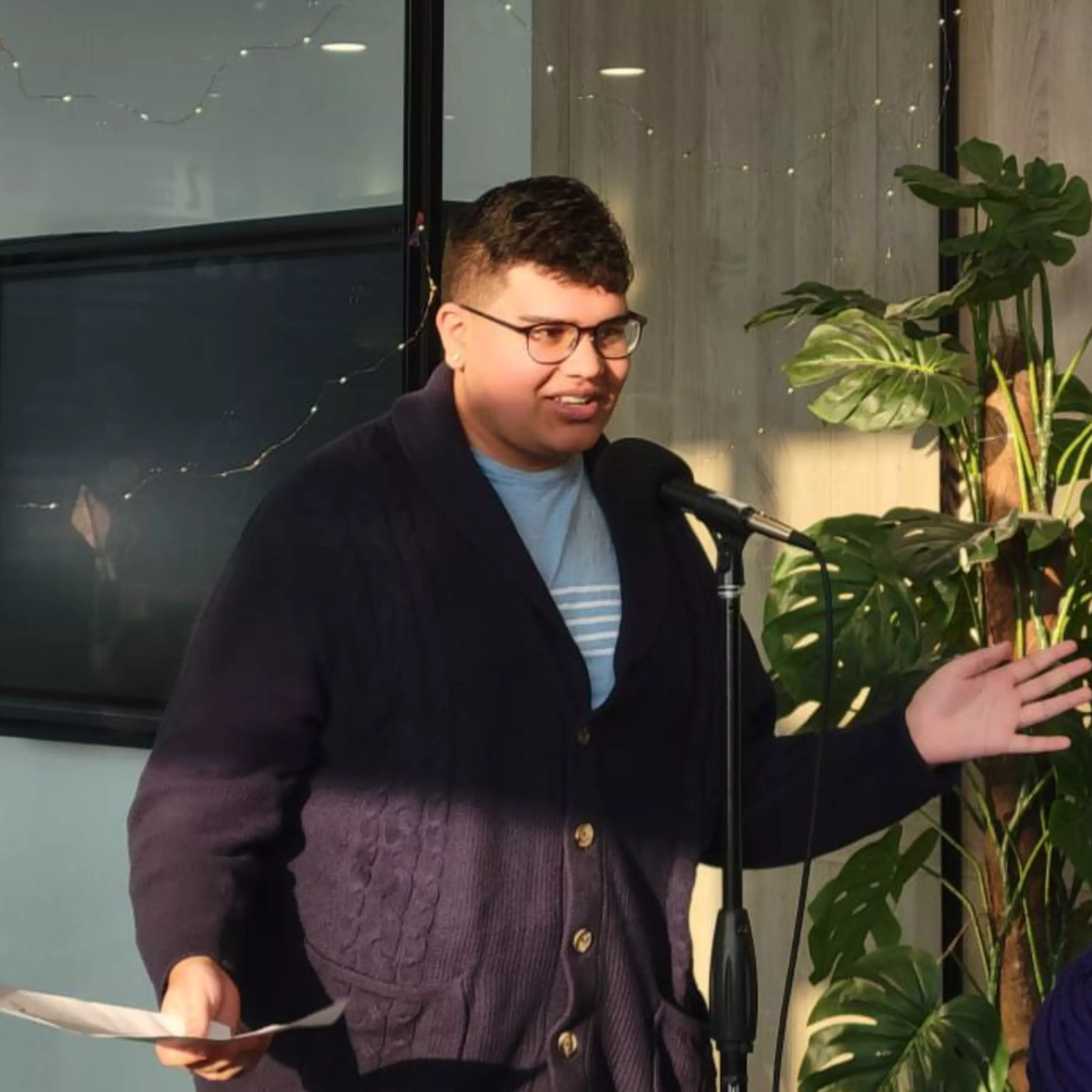 asian person standing and talking in front of microphone