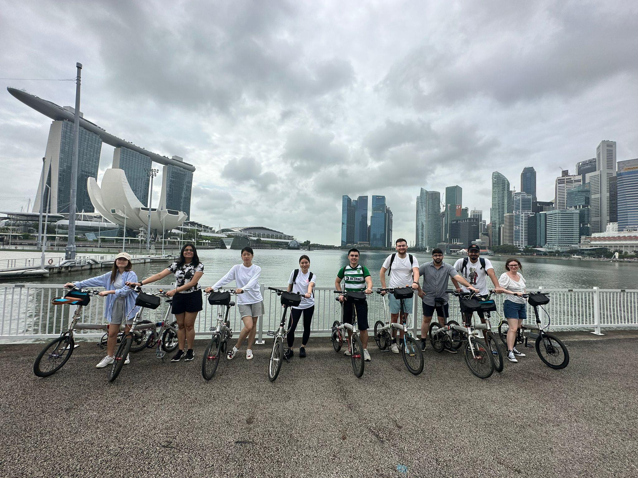 Image of participating ICM students with bikes against the background of downtown Singapore.