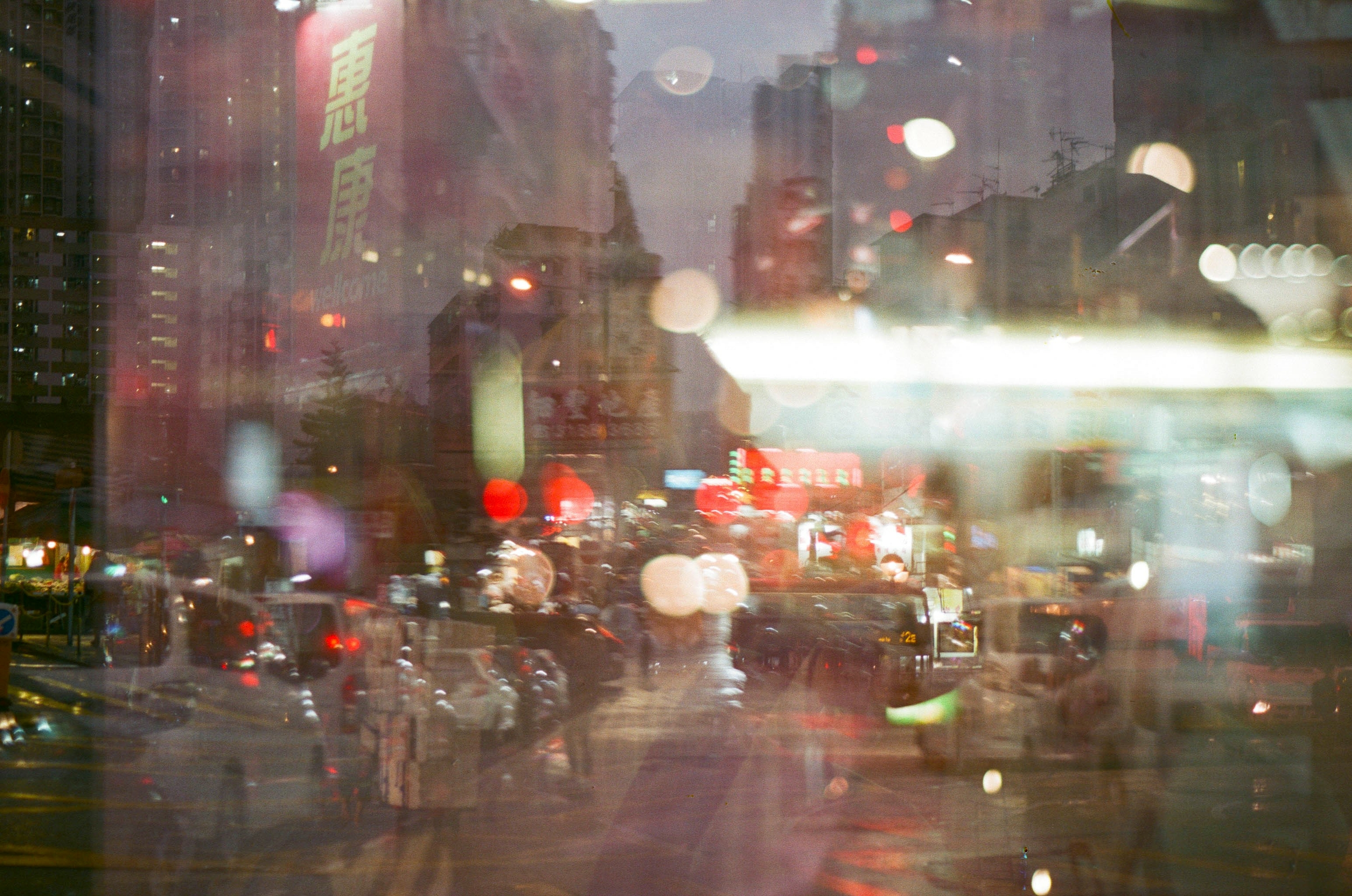 A street scene in Hong Kong with red lanterns, tall buildings in the background, dim lighting and blurred double exposure.