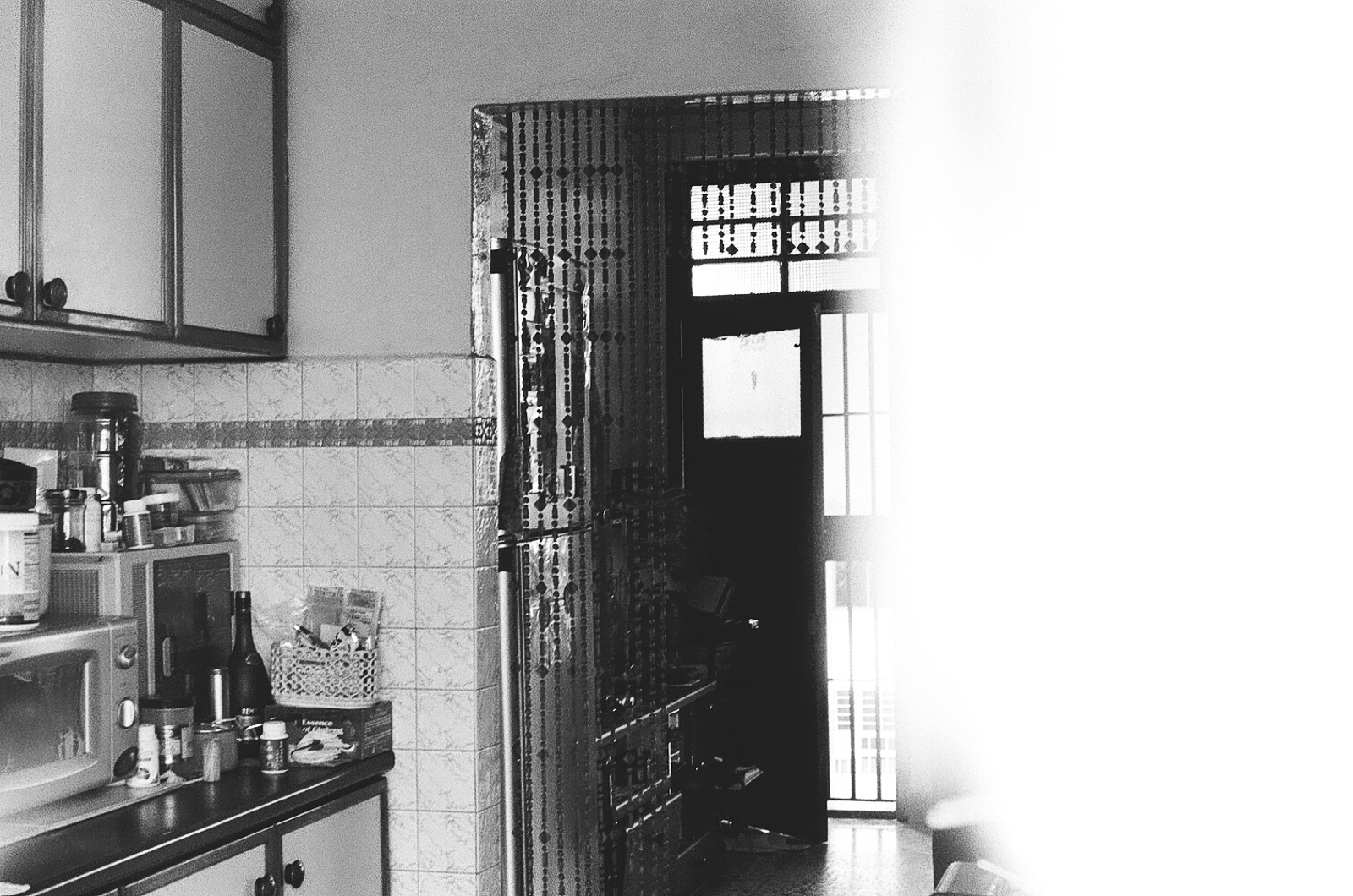 Black and white photo of the entrance to a kitchen from the street