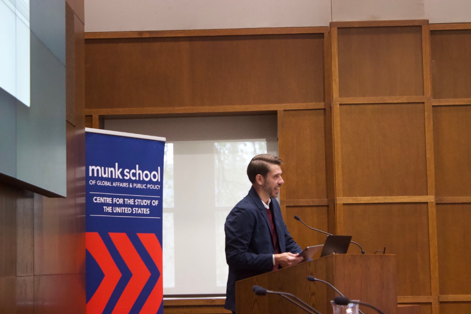 A person standing at a podium

Description automatically generated