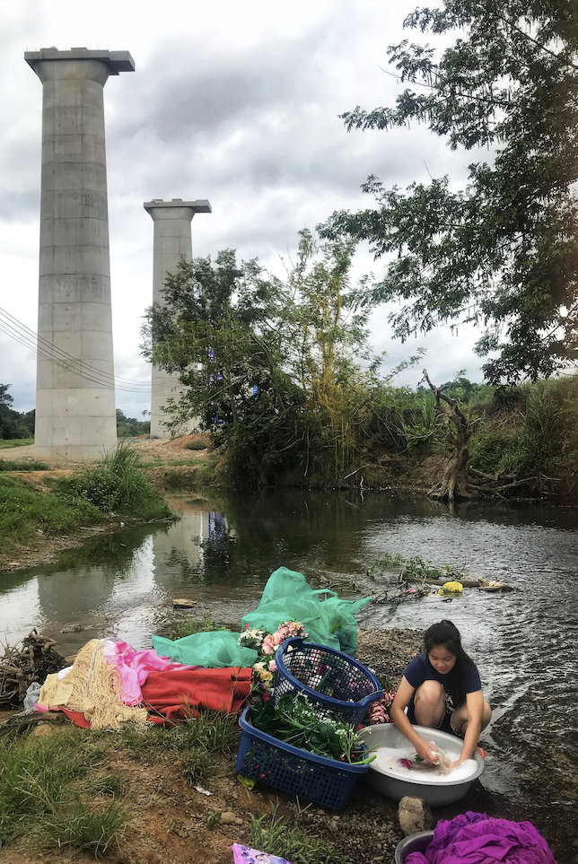 A woman washes clothes in a river