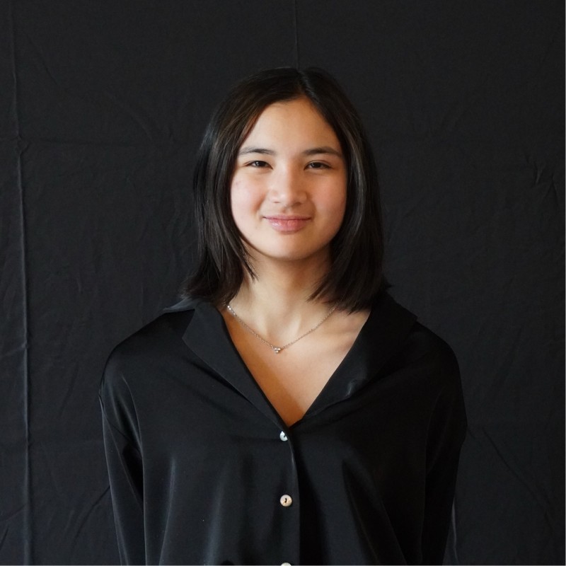 Photo of woman with black hair wearing a black cardigan.
