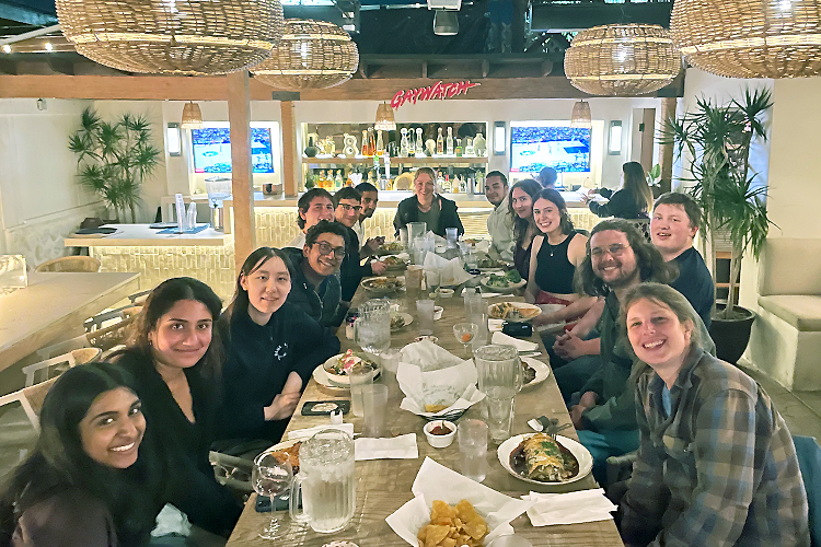 Picture of a group of students and faculty in a restaurant around a table.