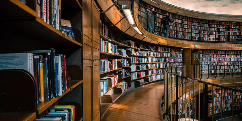 A curved library wall with shelves filled with books