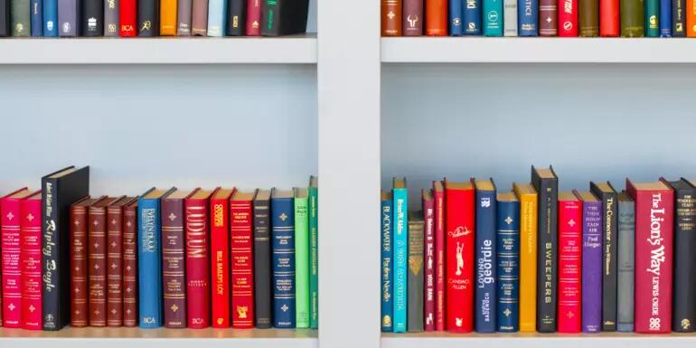 Colourful books on white shelves