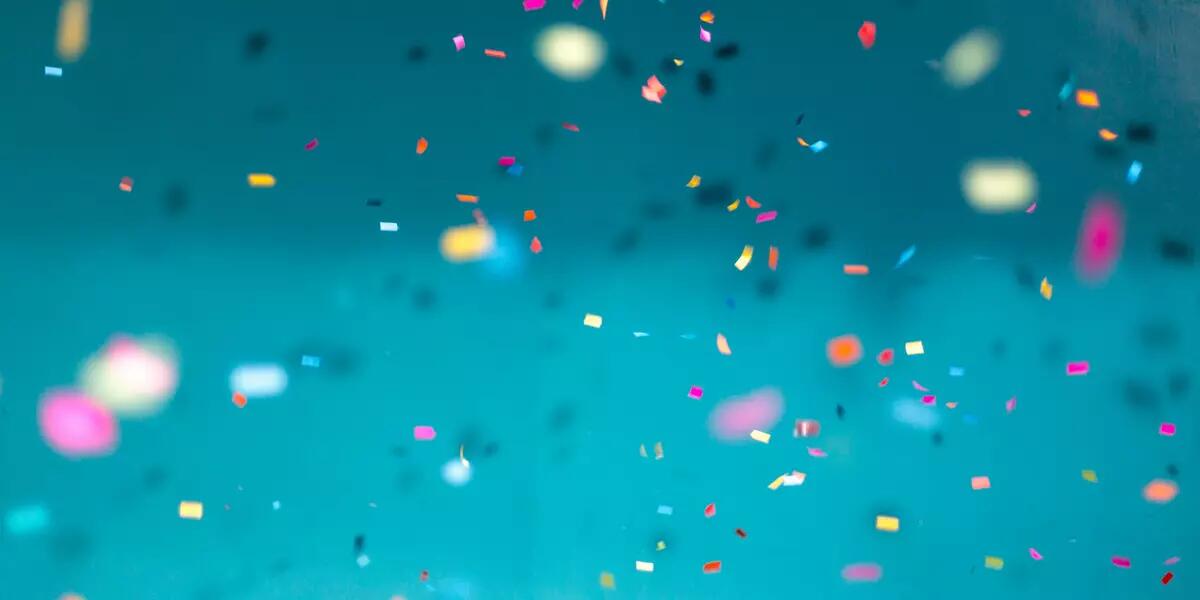 Colourful confetti against a teal blue background