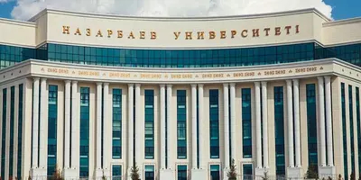 An impressive building, part of Nazarbayev University, against a blue sky.