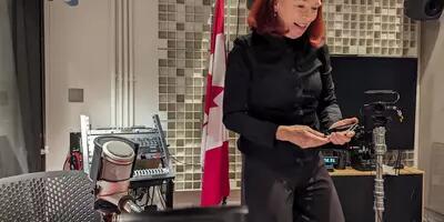 Catherine Tait on her phone while standing