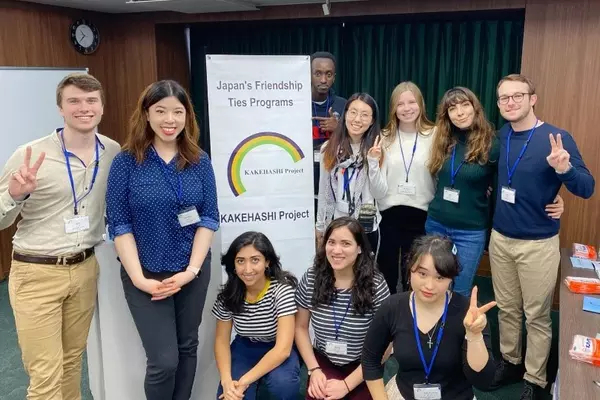 Ten students who participated in 2019-20 Kakehashi Project stand around a program banner