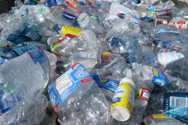 A large pile of dozens of empty plastic bottles