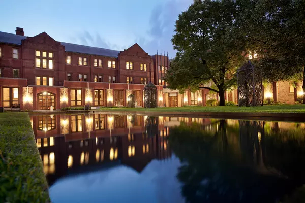 Exterior of Munk School's Devonshire building at night with reflecting pool
