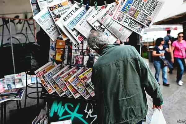 Man reading the newspaper from a newstand (Getty Images)