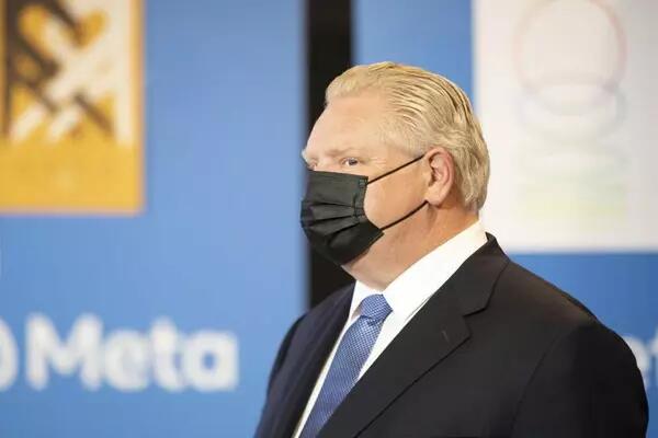 Doug Ford wearing a black mask and a suit/tie