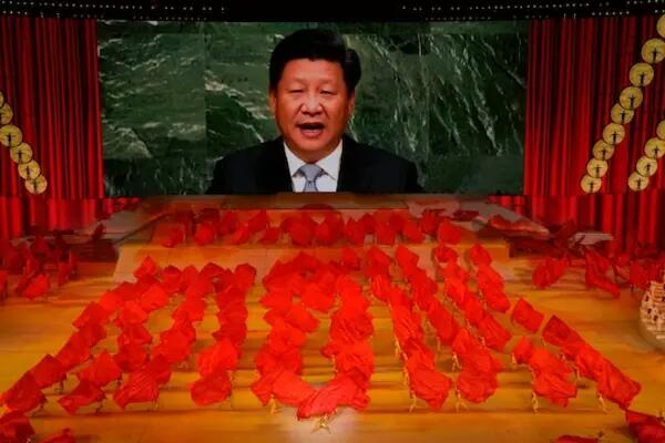 Chinese President Xi Jinping is shown on a screen as performers dance at a Beijing gal