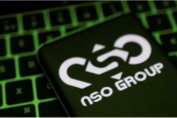 NSO Group logo on a phone, laying on a neon green backlit keyboard