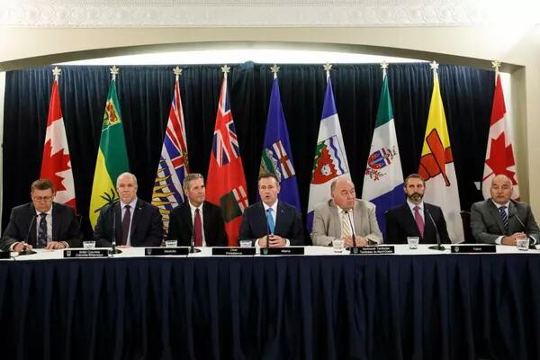 Western Canadian premiers seated in a line at a table