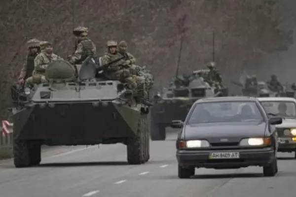 Soldiers on tanks on the road beside civilian cars