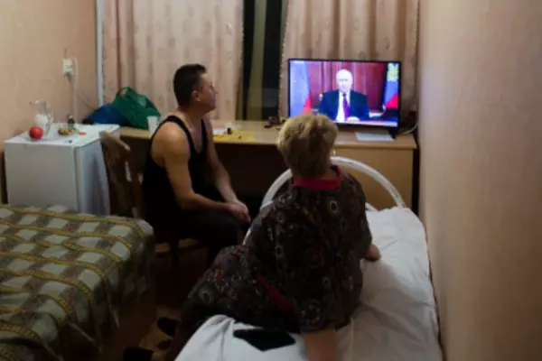 People from the Donetsk and Luhansk regions, the territory controlled by pro-Russia separatist governments in eastern Ukraine, watch Russian President Vladimir Putin’s address at their temporary home in the Rostov-on-Don region of Russia on Monday, February 21. Denis Kaminev/AP