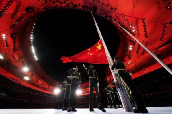 Chinese soldiers salute the Chinese flag at the Olympics