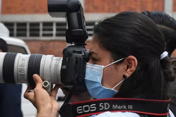A photojournalist wears a surgical mask during a press conference in San Salvador on April 21, 2020. YURI CORTEZ/AFP via Getty Images  