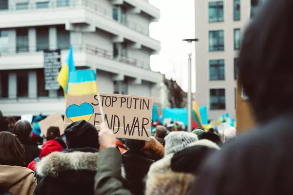 A view from inside a crowd of protestors with signs that read Stop Putin's War on Ukraine