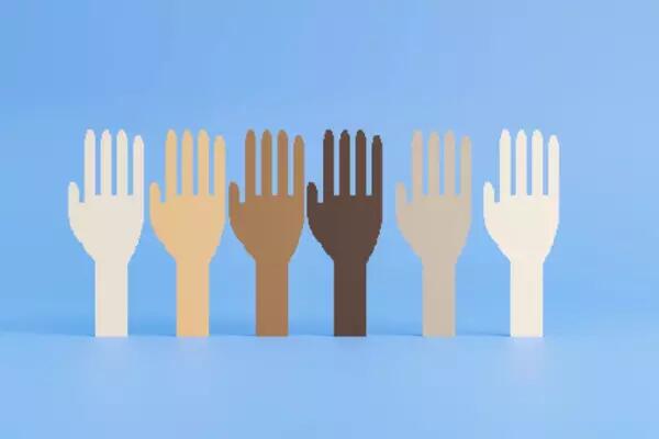 Raised hands of various skin colours