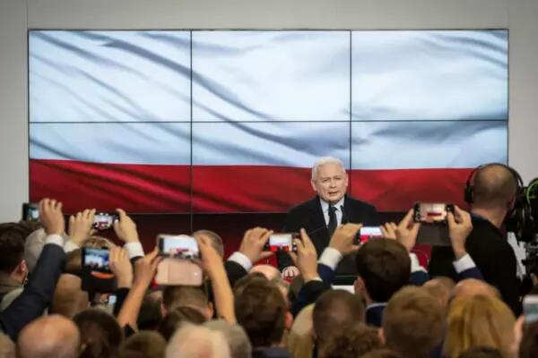 Jaroslaw Kaczynski, the leader of Poland’s Law and Justice party and the country’s deputy prime minister in front of a large Polish flag and reporters