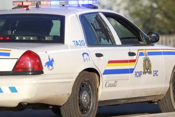An RCMP vehicle drives by with its window shattered by bullets