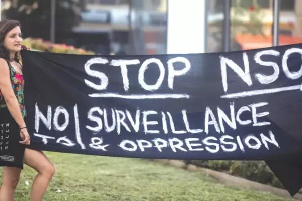 A girl holding a banner calling for stopping NSO: No surveillance and oppression