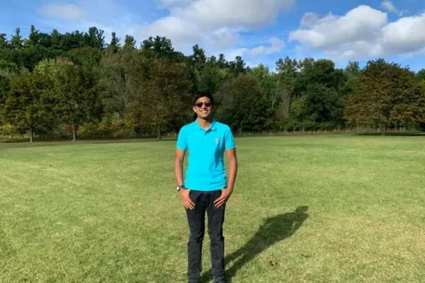 Atharv Agrawal in a blue shirt, standing in a field