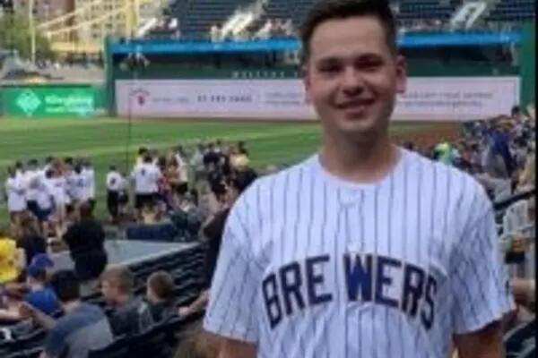 Adam Stasiewicz in a Brewers team jersey, standing in a sports stadium