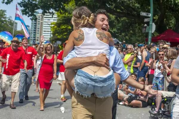 Justin Trudeau carries a woman at a Pride rally