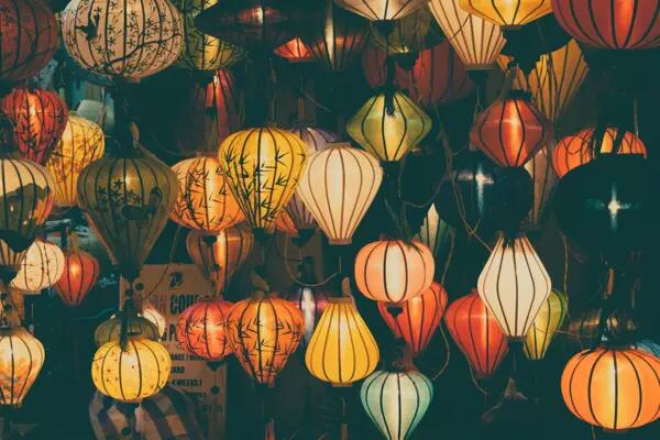 Dozens of multicoloured lanterns hanging from a ceiling