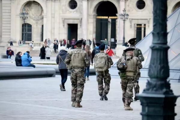 Three people in military clothes walk in Paris