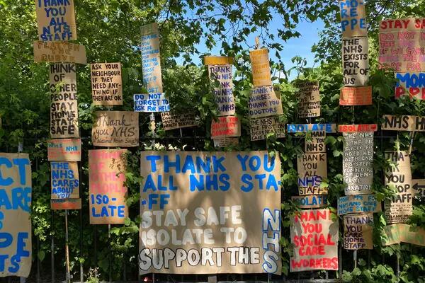 An installation of signs to thank the NHS and encourage community support on the railings of a park in east London. There were hundreds of signs painted on cardboard.