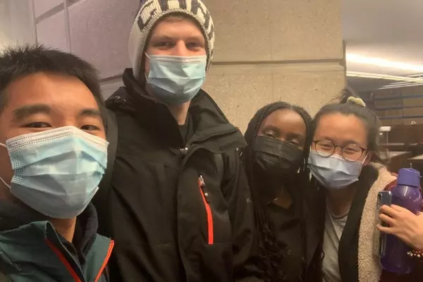 Four participants from the 2021 Munk One case competition, all wearing masks