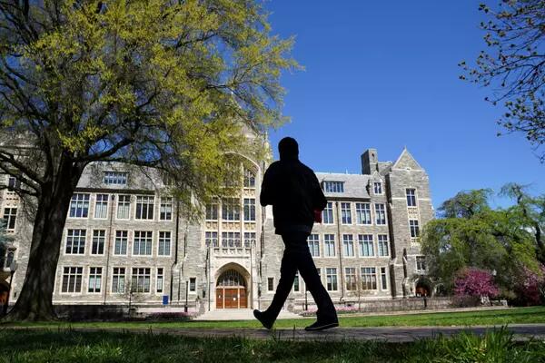 A man walks at an empty campus green at Georgetown University, closed weeks ago due to coronavirus, in Washington