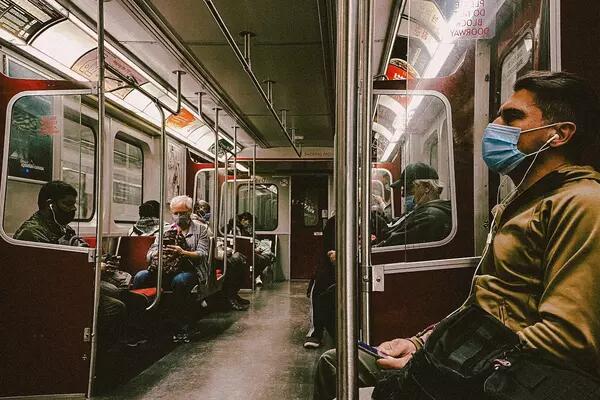 Masked individuals ride the subway in Toronto